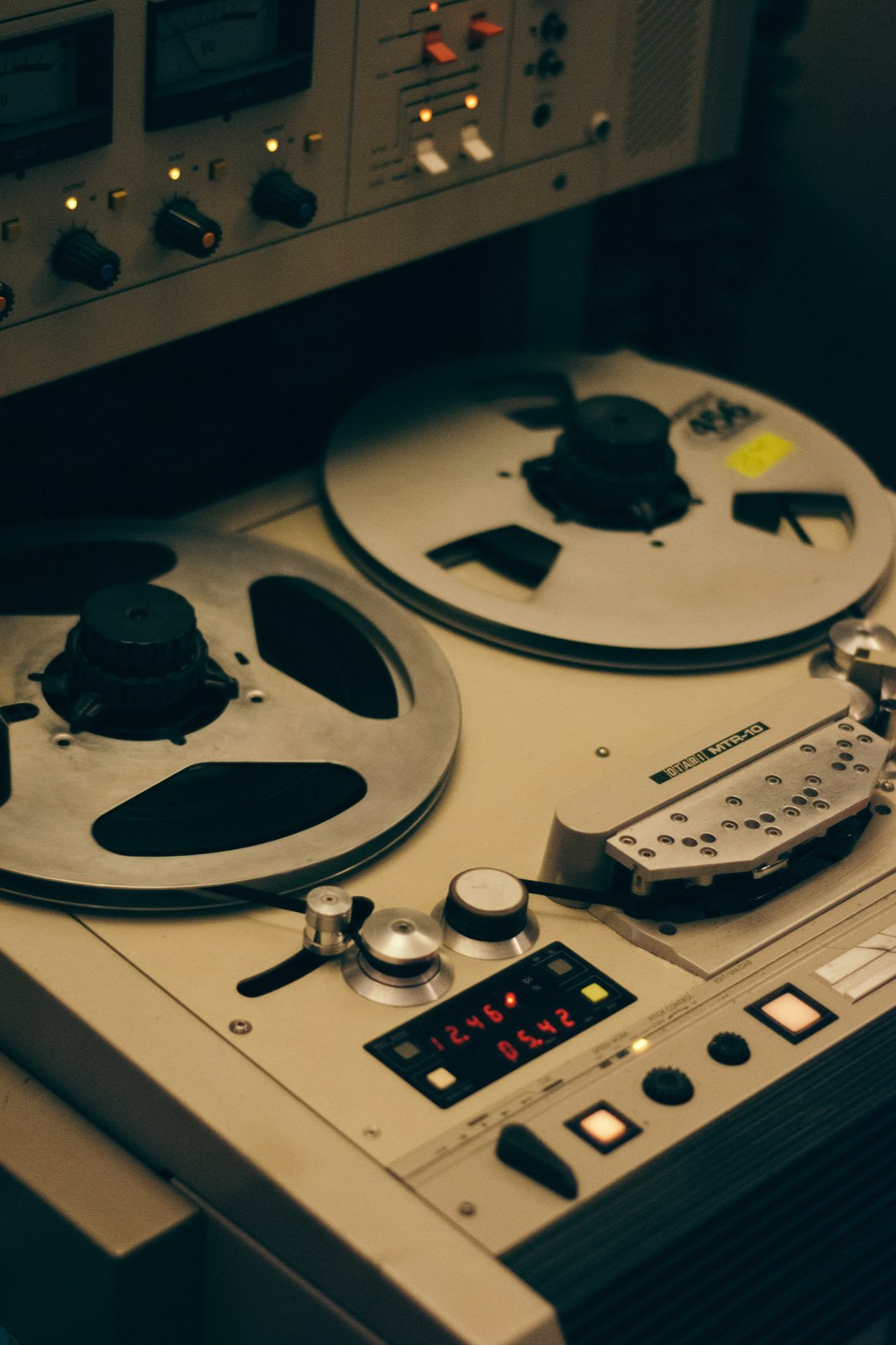 An Otari MTR-10 reel-to-reel tape recorder with studio outboard gear